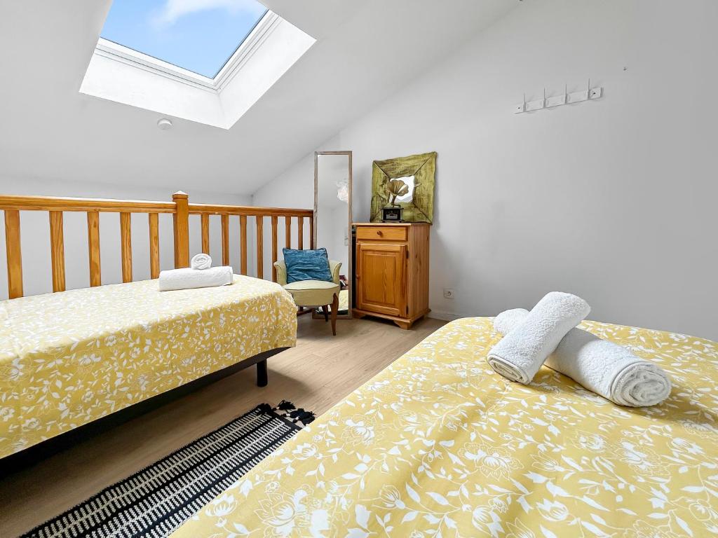 ein Schlafzimmer mit zwei Betten und einem Dachfenster in der Unterkunft Vue mer panoramique, Loggia Salon, Parking Privé in Saint-Hilaire-de-Riez