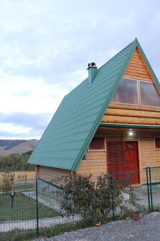 a wooden house with a green roof at ZlatniBor House Zlatibor in Vodice