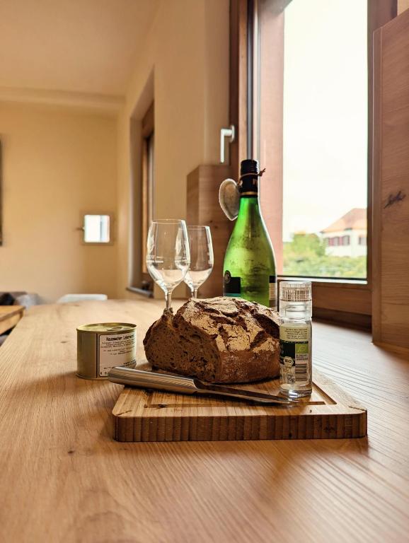 a table with a loaf of bread and two wine glasses at Ferienhaus am Gässchen in Edesheim