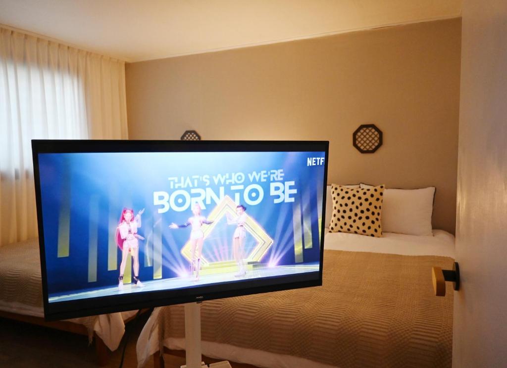 a flat screen tv sitting on a stand in a bedroom at Stay Onjeong Jamsil Accommodation in Seoul