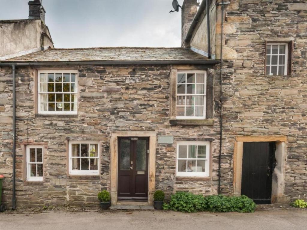 una antigua casa de piedra con ventanas blancas y una puerta en 2 Bed in High Lorton SZ136, en Lorton
