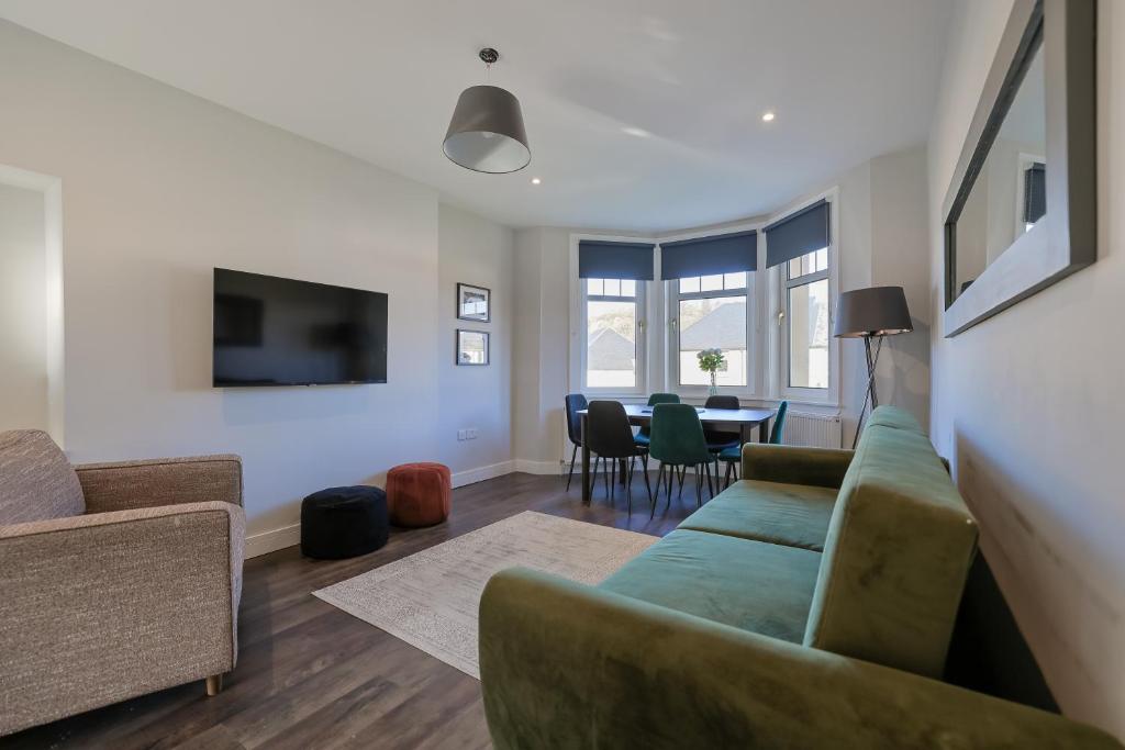 a living room with a couch and a table at The White City Apartment in Oban