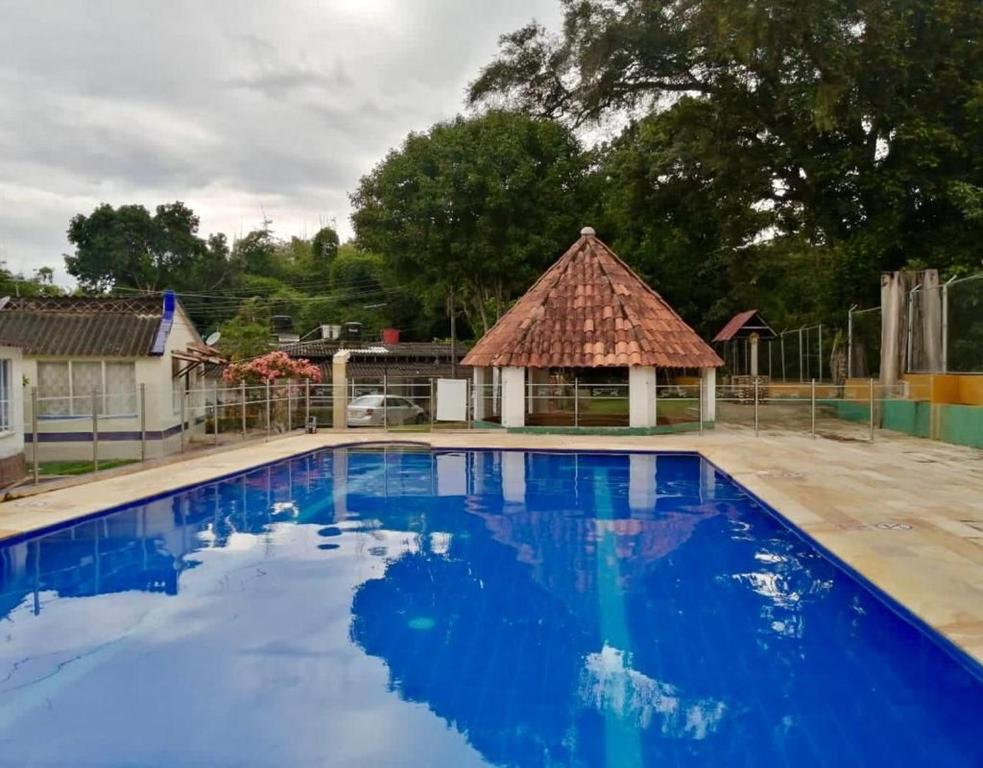 a large blue swimming pool with a gazebo at Cabaña brisa melgar in Melgar