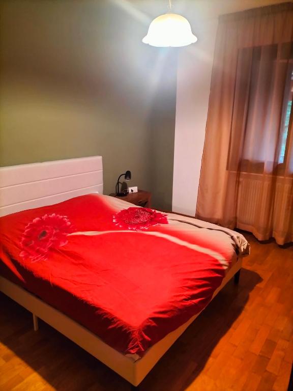 a bedroom with a red bed with a red blanket at Locazione turistica Gisella 