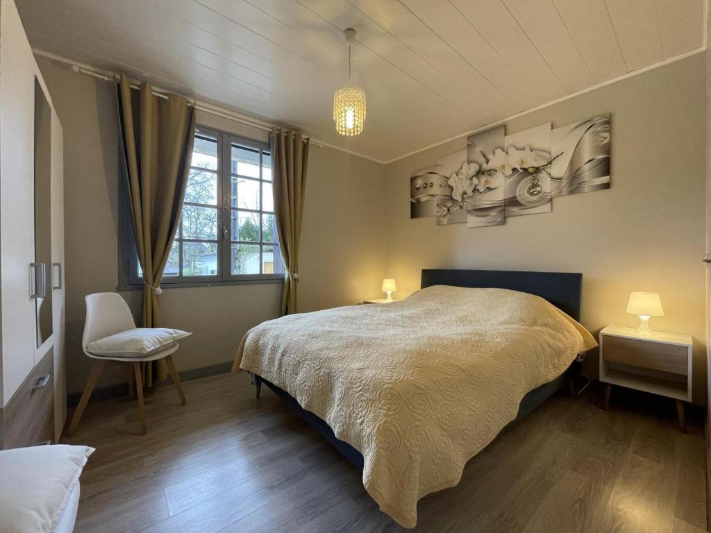 a bedroom with a large bed and a chair at Jardin fleuri in Sus