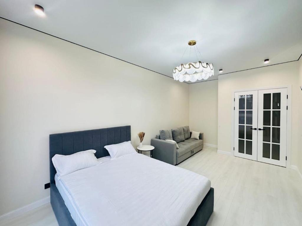 um quarto com uma cama grande e um sofá em Shabyt Apartments em Astana