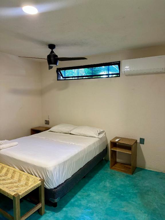 a bedroom with a white bed and a window at PointBreak Surfhouse in Puerto Escondido