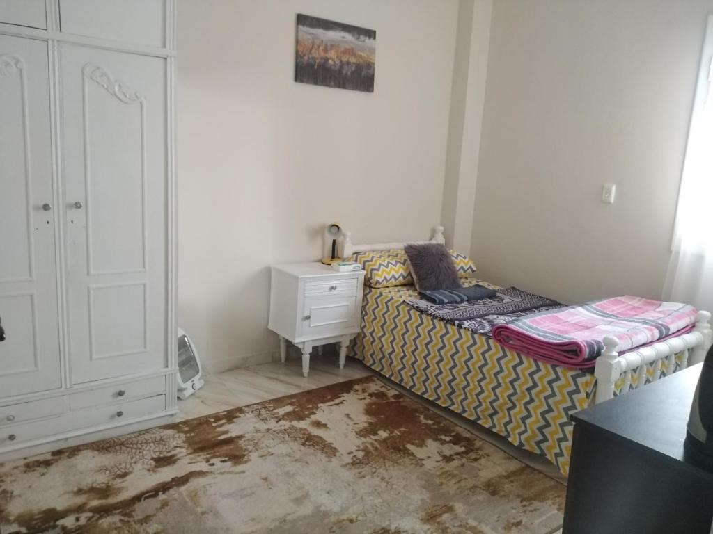 a bedroom with a bed and a dresser and a night stand at Gardenia Hotel in 6th Of October