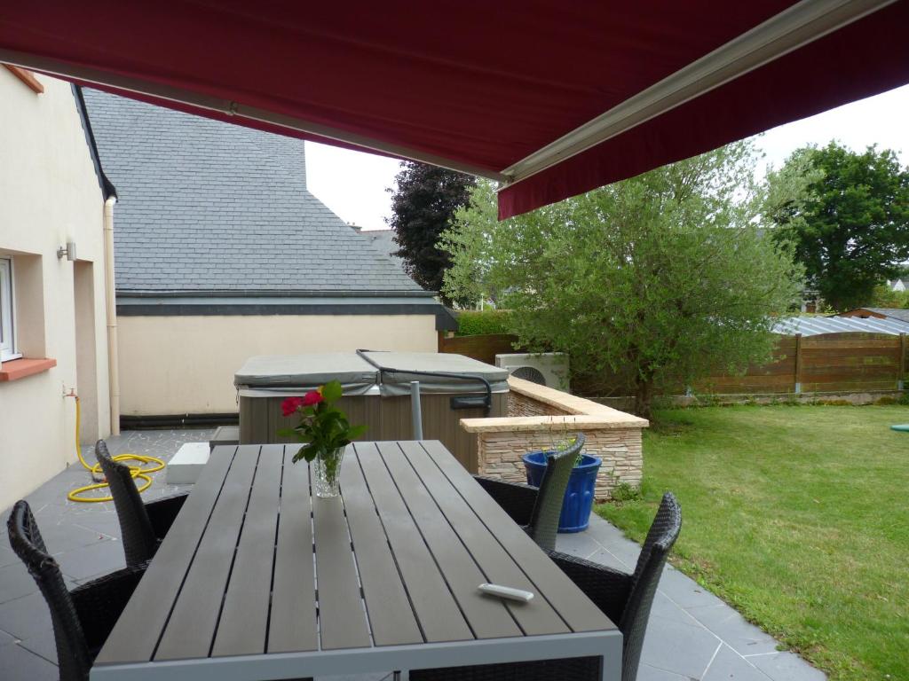 a wooden table and chairs on a patio at Ti harmoniel in Guingamp