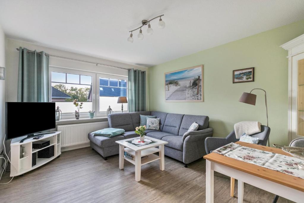 a living room with a couch and a tv at Ferienhaus Smilla in Meldorf