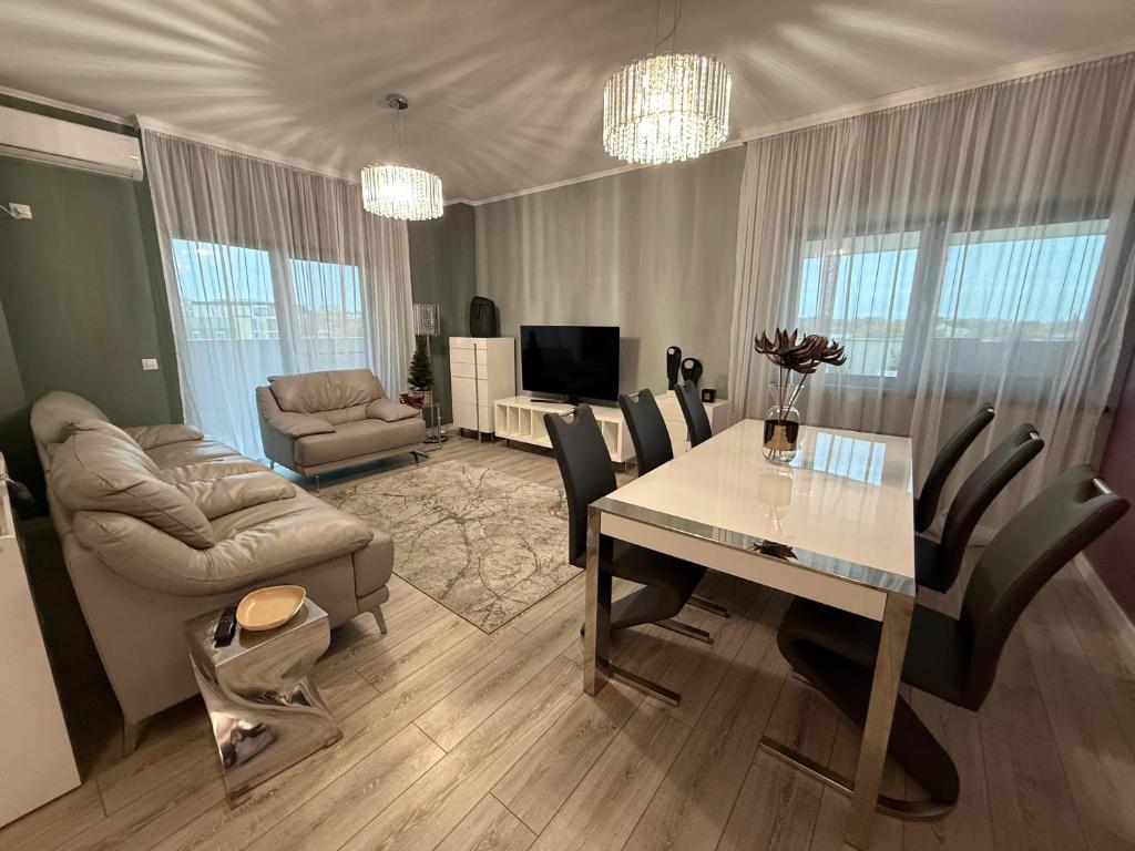 a living room with a dining room table and a couch at Premium Apartment in Craiova