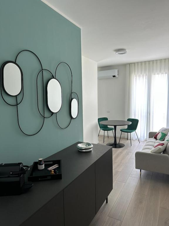 a living room with three mirrors on the wall at OFF 32 Suites in Melzo