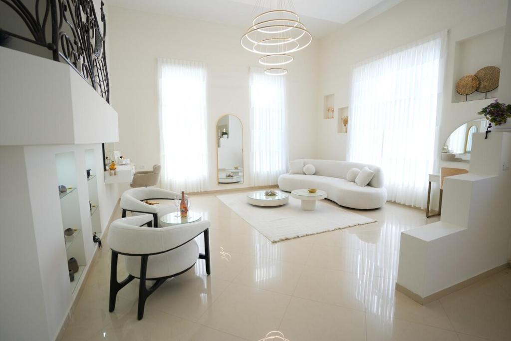 Biały salon z kanapą, stołem i krzesłami w obiekcie ווילה בנאות לון w mieście Beer Szewa
