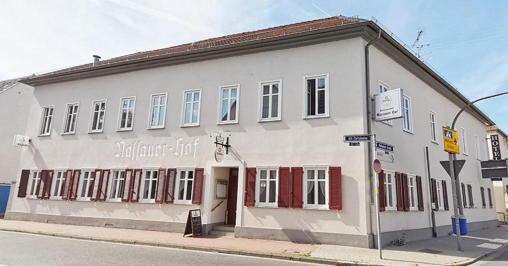 a white building with red doors on a street at Hotel Nassauer Hof Frankfurt in Frankfurt/Main