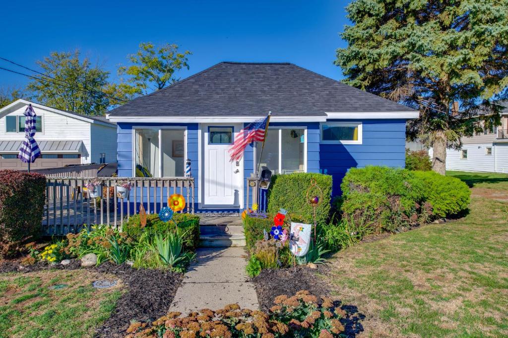 une maison bleue avec un drapeau américain dans une cour dans l'établissement Deck with Views Lakeside Spring Lake Cottage, à Spring Lake