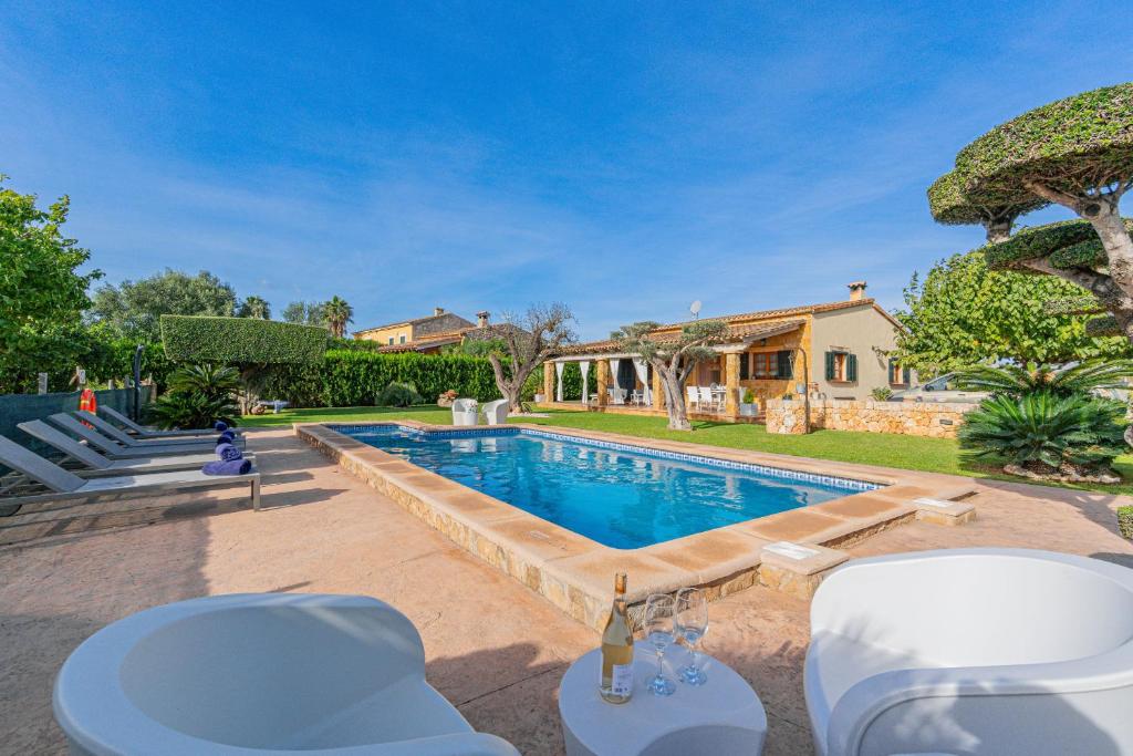 ein Swimmingpool mit Stühlen und ein Haus in der Unterkunft Villa Hortet den Joan By home villas 360 in Alcúdia