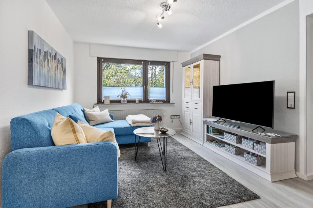 a living room with a blue couch and a tv at Ferienwohnung an der Volme in Meinerzhagen