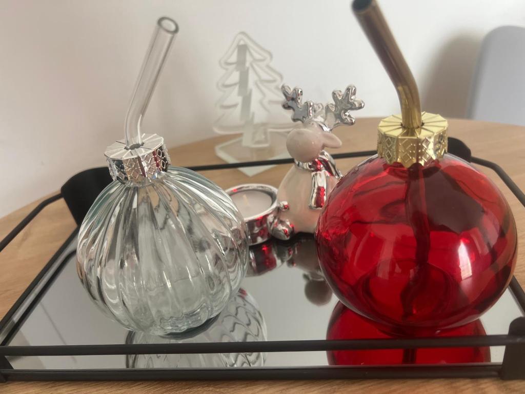 een tafel met een rood ornament en een vaas erop bij Apartament Niebieski Centrum Sarbinowo w budynku z restauracją in Sarbinowo