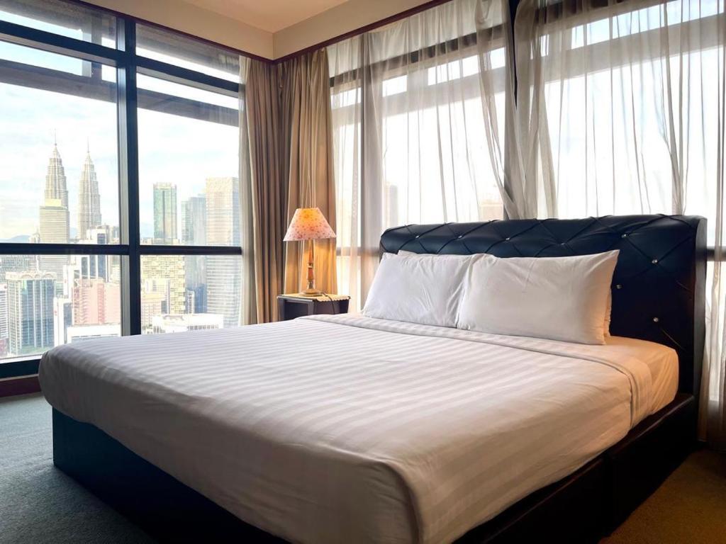 een slaapkamer met een groot bed met een groot raam bij Eco suites at times square in Kuala Lumpur