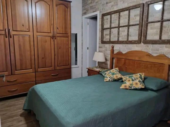 ein Schlafzimmer mit einem großen Bett mit einem hölzernen Kopfteil in der Unterkunft Casa de ferias in Balneário Camboriú