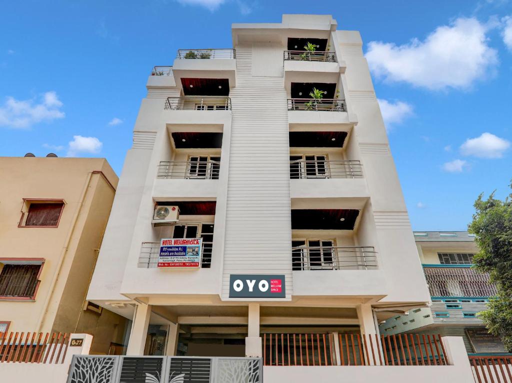 a tall white building with a sign in front of it at Hotel O Mellow Space in Patna