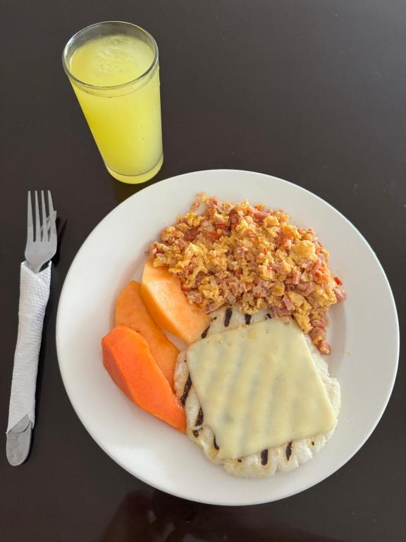 巴耶杜帕尔Hotel Buenavista Valledupar的盘子上放着肉饭和一杯果汁