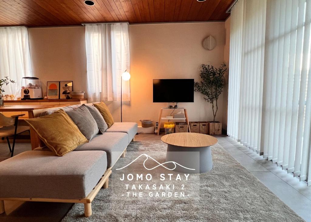 a living room with a couch and a tv at Jomo Stay Takasaki 2 -the Garden- in Takasaki