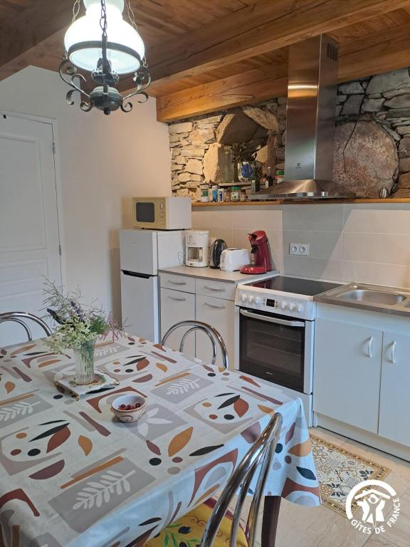 a kitchen with a table with a table cloth on it at Rossignol in Le Bez