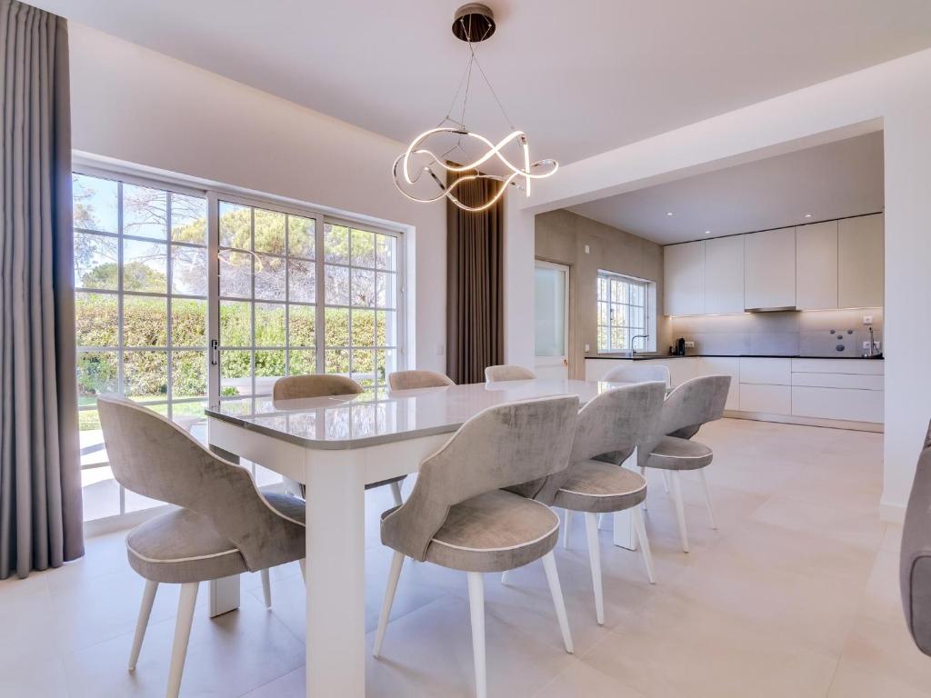 a white dining room with a white table and chairs at Casa Nuria com 4 quartos, piscina e churrasco em Vale do Lobo in Almancil