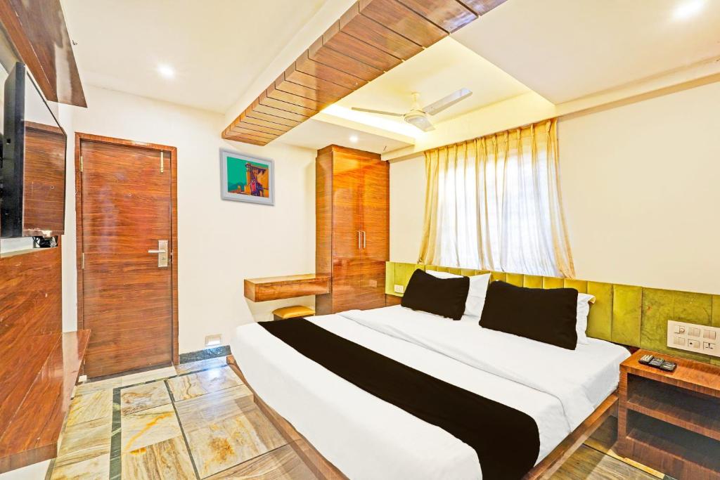 un dormitorio con una cama grande en una habitación en Collection O Chidambaram Stadium Formerly Hotel Admire Suit, en Chennai