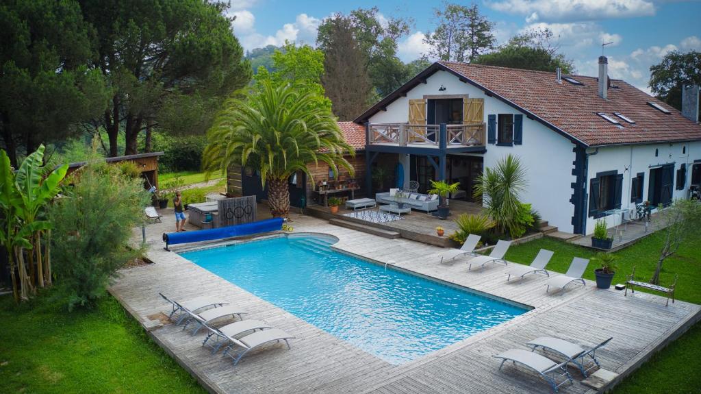 an overhead view of a swimming pool with chairs and a house at La Belle Landaise 1809 Gîte Arridoulet 1 in Peyrehorade