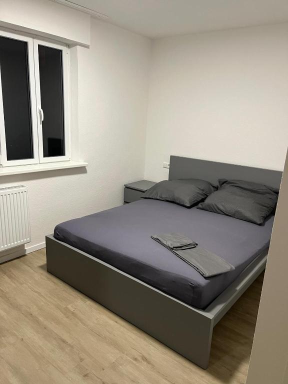 ein Bett in einem weißen Zimmer mit einem Fenster in der Unterkunft Appartement 1 in Stuttgart