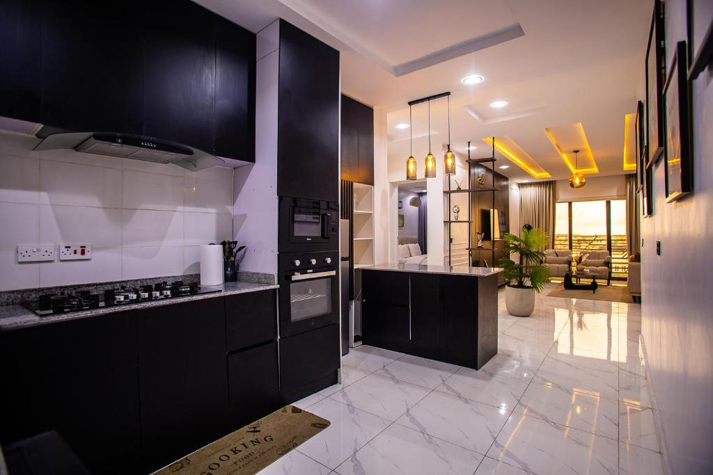 Una cocina con gabinetes negros y encimera. en Luxuryliveinn, en Mama