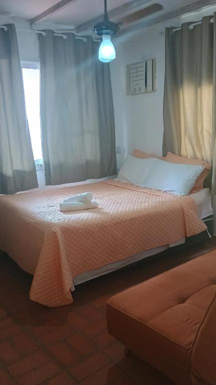 a bedroom with two beds and a window with curtains at Quarto com Ar à 500m da praia Espaco Aconchego do Gugu in Arraial do Cabo