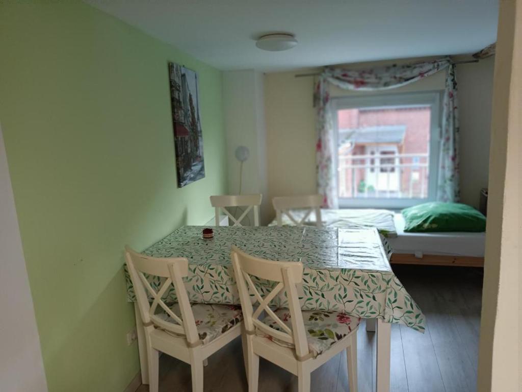 a room with a table and two chairs and a bed at NEU! Ferienwohnung Storchennest OG in Pömmelte
