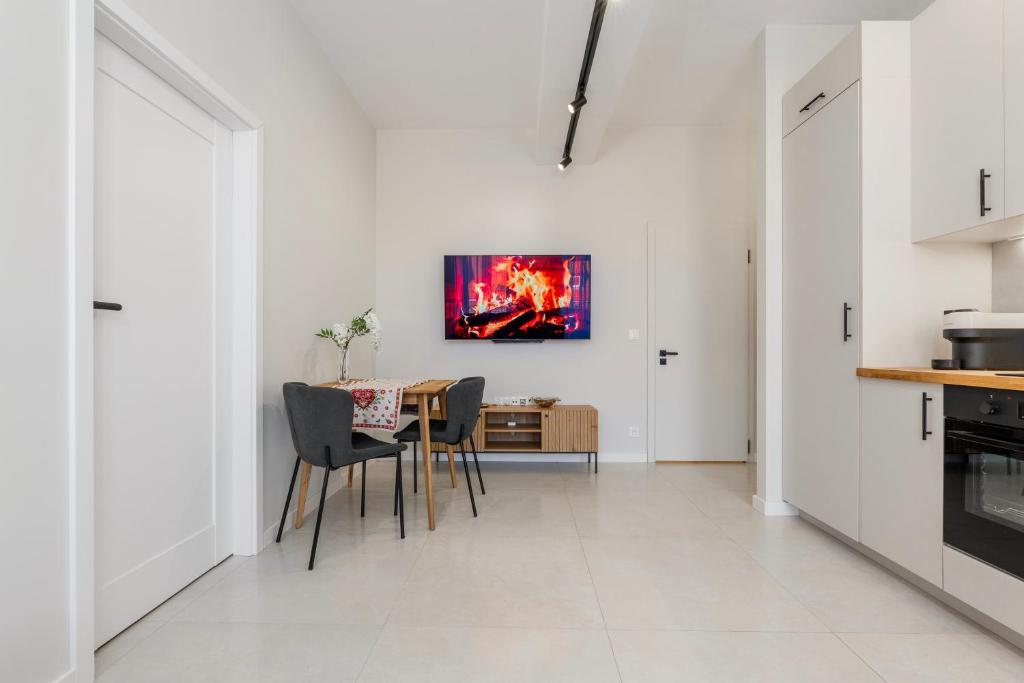 a kitchen and dining room with a table and chairs at K26UrbanNest in Wrocław