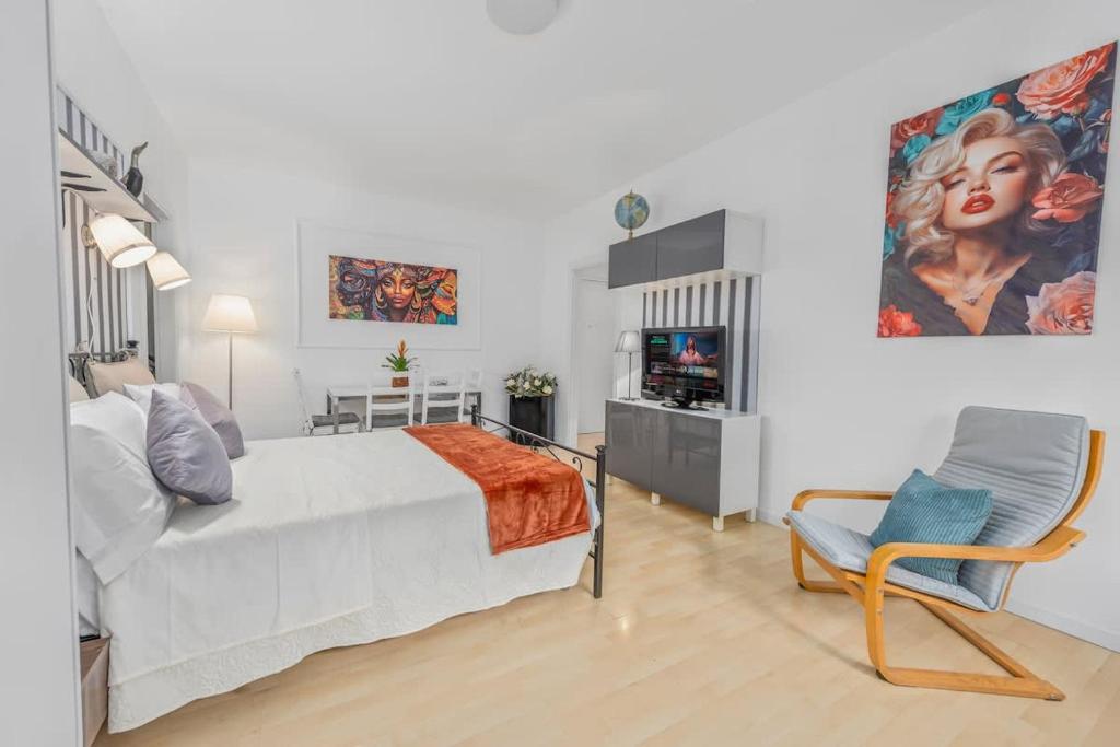 ein Schlafzimmer mit einem großen weißen Bett und einem Stuhl in der Unterkunft Lakeside Hideaway - Lakefront & Central in Lecco