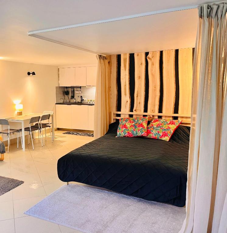a bedroom with a black bed with pillows on it at Woodstock IX, self check-in in Riga
