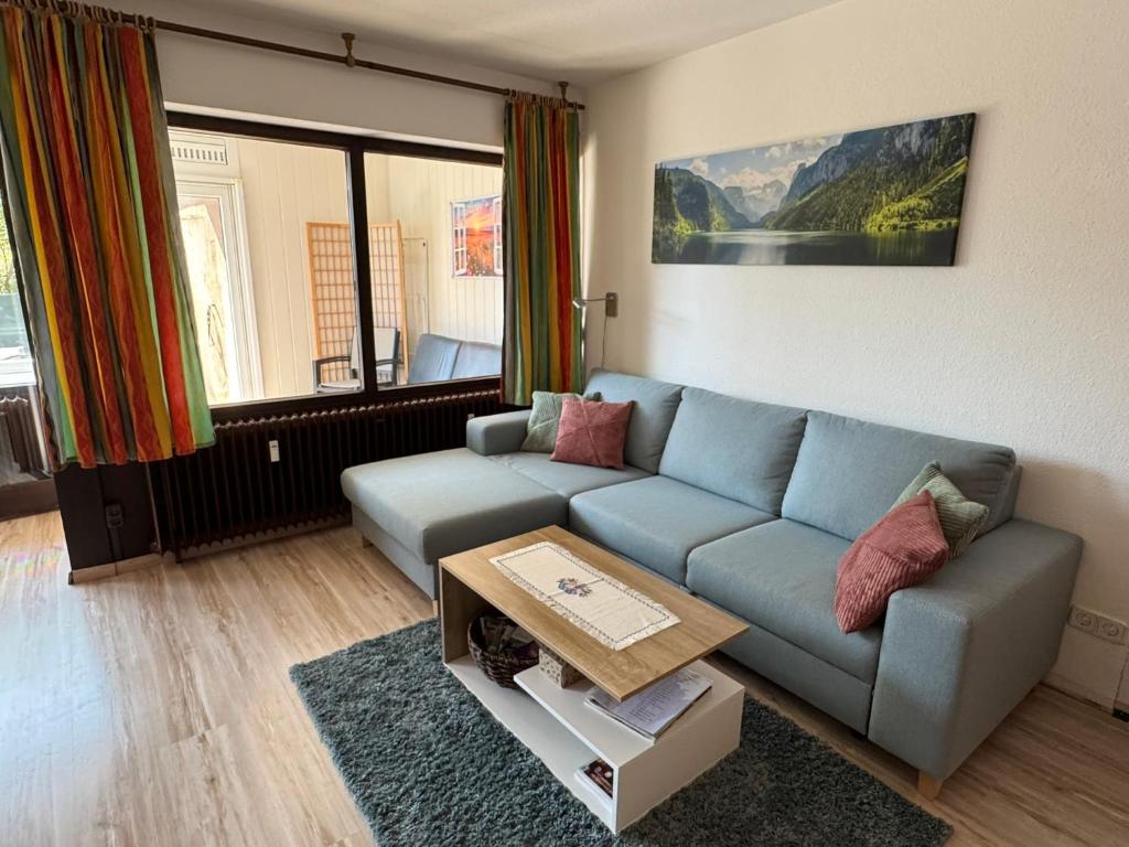 a living room with a blue couch and a table at Ferienwohnung Sunnabichi in Wertach