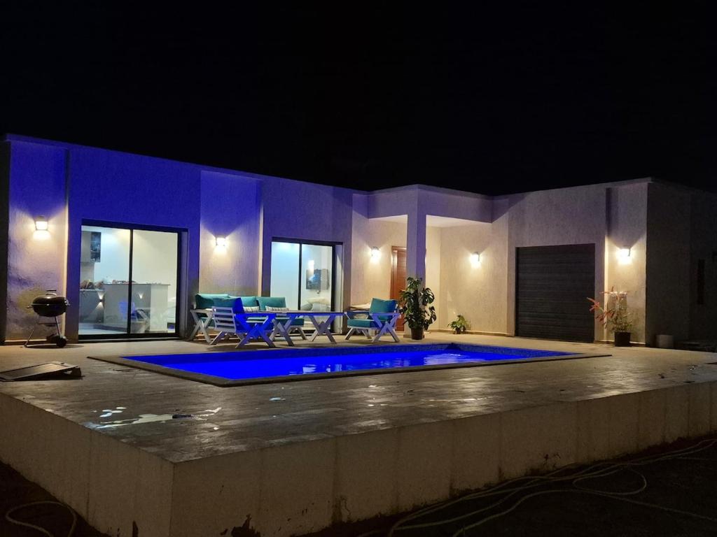a house with a swimming pool at night at Villa Midoun in Midoun