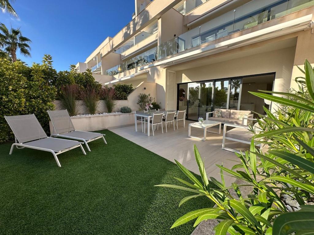 een patio met stoelen en een tafel voor een gebouw bij Luxury 2 bed apartment in Las Colinas in Orihuela-Costa