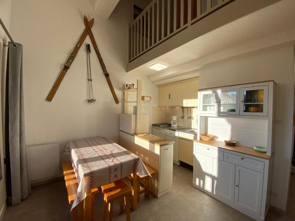 a kitchen with a table and a small kitchen with a table and chairs at Appartement 2P Mezzanine, 2 SDB, 6-7 couchages aux Saisies - FR-1-293-75 in Les Saisies