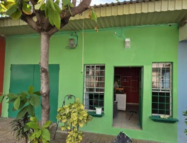 ein grünes Haus mit einem Baum davor in der Unterkunft Casa Vistagolfo in La Unión