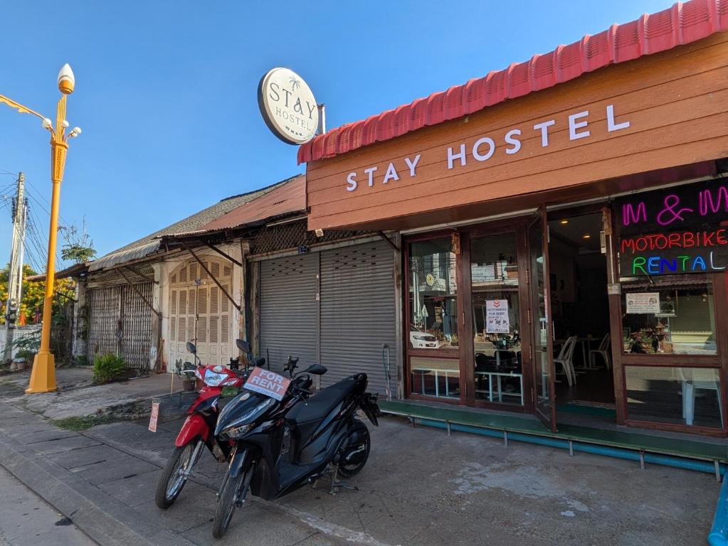 a motorcycle parked in front of a shop with a clock at STAY HOSTEL - MOTORBIKE & LOCKER RENTAL Thakhek in Thakhek