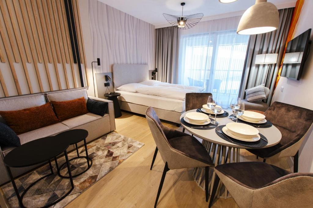 a living room with a couch and a table with chairs at VacationClub - Baltic Waves Resort Apartament A109 in Międzyzdroje