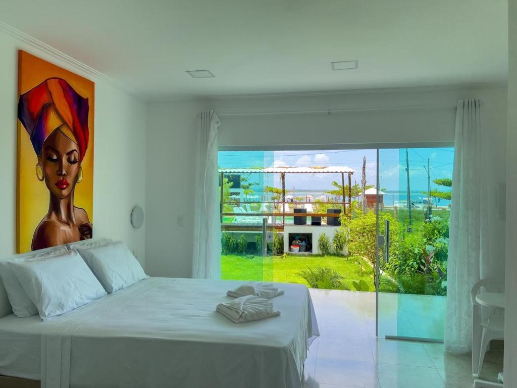 a bedroom with a bed with a painting on the wall at Mambo beach gamboa in Cayru