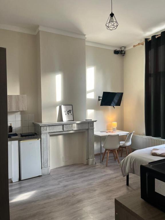 a living room with a desk and a table in a room at European District Hostel in Brussels