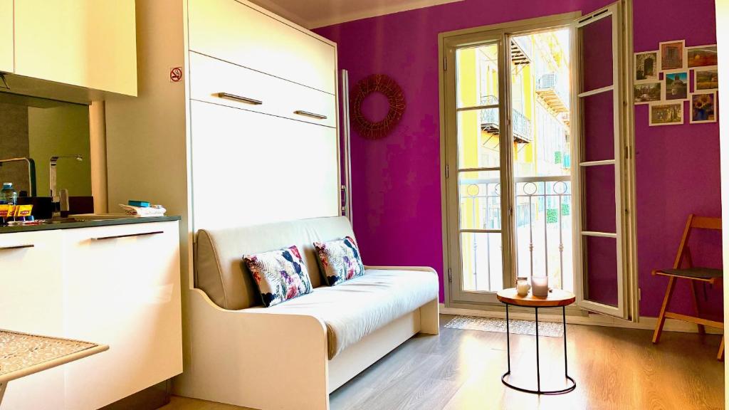 a living room with a couch and a window at ApartHotel Riviera Nice Côte d'Azur - Old Town - Studio AC - Sea View - 50m Promenade des Anglais- LA MAISON LINDA in Nice