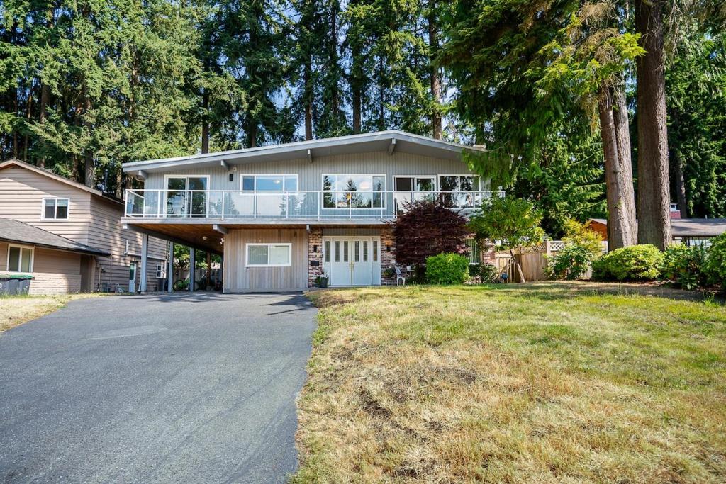 una grande casa con balcone e vialetto di Serene Nature Retreat a North Vancouver