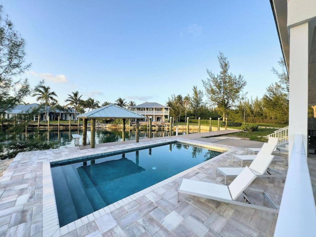 una piscina con cenador y una casa en Escape to Paradise In West End Old Bahama Bay, en West End